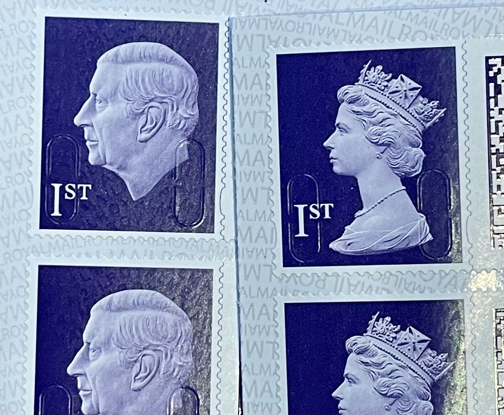 UK stamps. One showing the Queen the other the new guy. Side head portraits on a purple background. Marked as 1st (class)